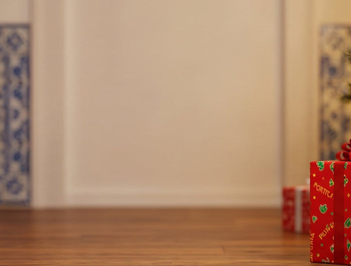 Gifts wrapped in Portuguese wrapping paper by a Christmas tree
