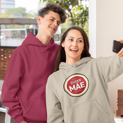 Two people taking a selfie, one wearing a maroon hoodie and the other wearing a gray hoodie with a 'Super Mae' logo.
