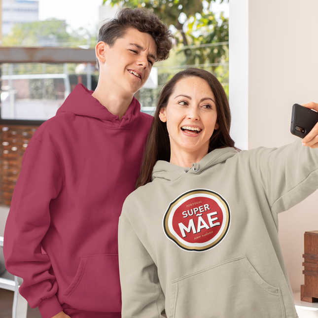 Two people taking a selfie, one wearing a maroon hoodie and the other wearing a gray hoodie with a 'Super Mae' logo.