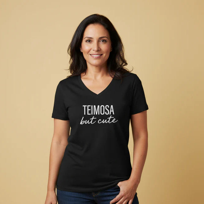 Woman wearing a black t-shirt with 'TEIMOSA but cute' text on a beige background